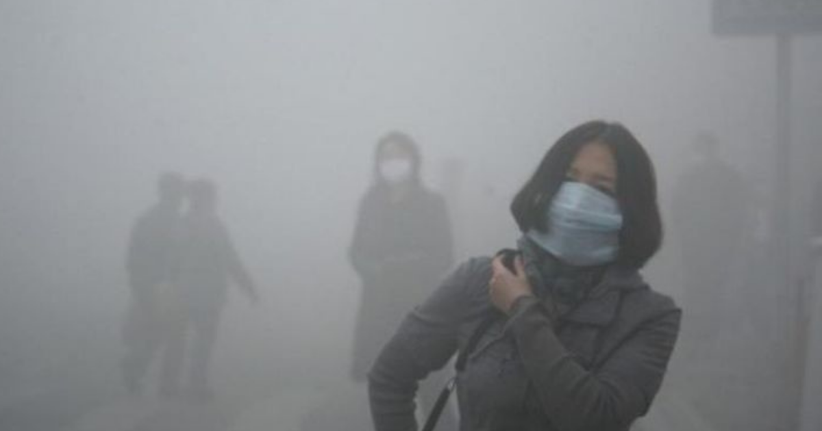 धुंध और स्मॉग से ढकी दिल्ली की सड़कें, मास्क पहने लोग खराब वायु गुणवत्ता में चलते हुए।